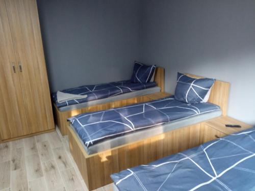 duas camas num pequeno quarto com lençóis azuis em M3 - Mieszkanie 2 pokoje , kuchnia , łazienka em Grodzisk Mazowiecki