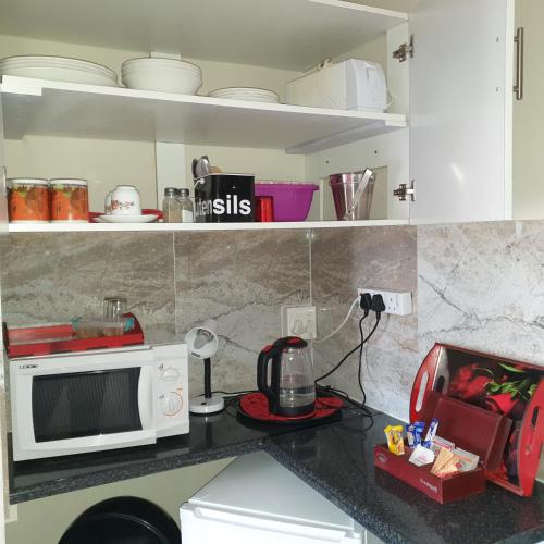 a kitchen counter with a microwave and a toaster at The Haven: Make our Home your Home in Estcourt