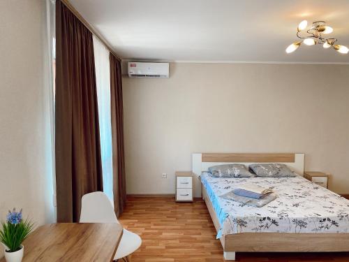 Un dormitorio con una cama y una mesa. en Apartment Sobornyi Prospect 95 en Zaporiyia