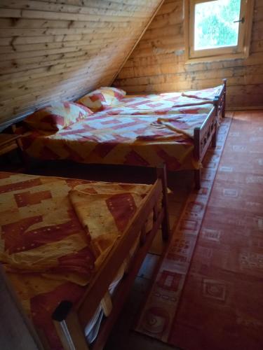 a room with two beds in a log cabin at Vikendica in Čanj