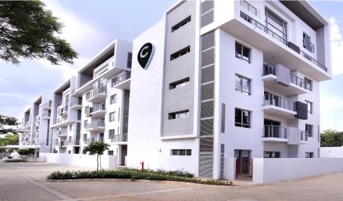 a white apartment building with a clock on it at The Capital on Bath in Johannesburg