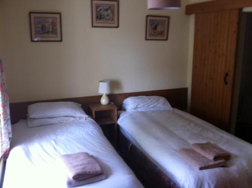 two beds sitting next to each other in a room at The Stables - 200 Year Old Stone Built Cottage in Foxford