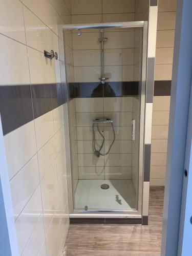 a shower with a glass door in a bathroom at Le Relais Du Velors in Beaumont-en-Véron