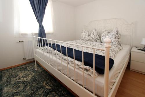 a white crib in a bedroom with a window at Steira-Studios Leibnitz in Leibnitz