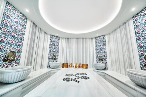 a white room with two sinks and windows at Stara Čaršija Hotel & SPA in Bar