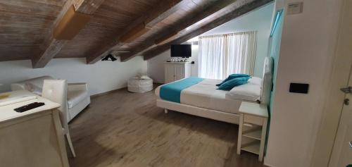 a bedroom with a bed and a desk and a window at Duomo Attic (rooms) in Ravello