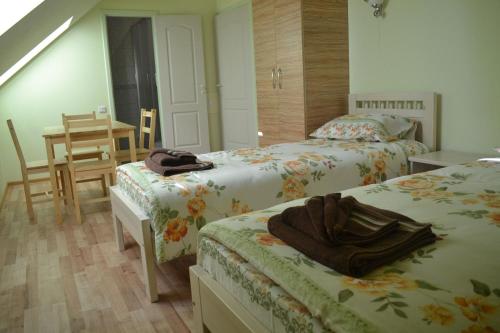 a bedroom with two beds and a table and a table at Arsenal in Daugavpils