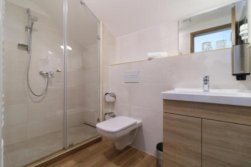 a bathroom with a shower and a toilet and a sink at Villa Marina Inn in Siófok
