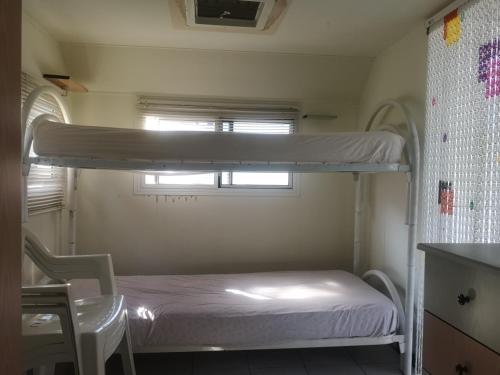 Ce lit superposé se trouve dans une petite chambre dotée d'une fenêtre. dans l'établissement Villaggio Mondial Camping, à Métaponte