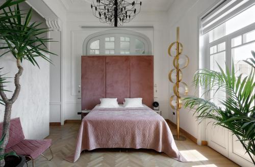 a bedroom with a bed and a chandelier at Aristide Hotel - Small Luxury Hotels of the World in Ermoupoli