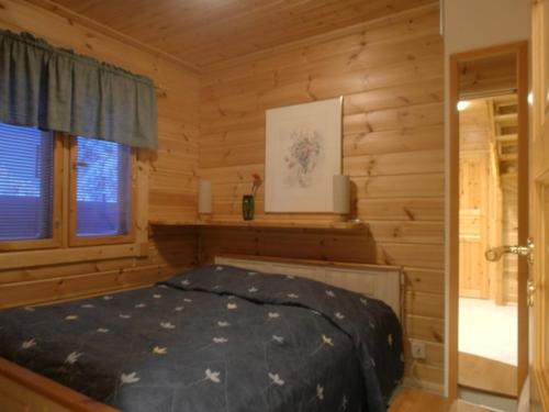a bedroom with a bed in a log cabin at Ilvestie A in Syöte