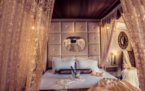 a bedroom with a bed with curtains and a mirror at Abbacy Katiana's Castelleti 1 in Limenas
