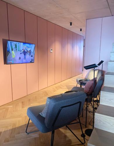 a room with two chairs and a tv on the wall at Oporto CoLiving Monte Ramalde in Porto