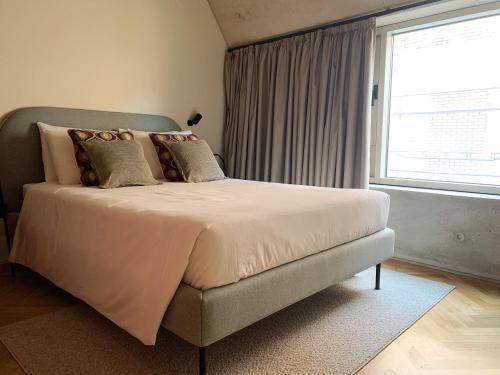 a bed in a bedroom with a large window at Oporto CoLiving Monte Ramalde in Porto