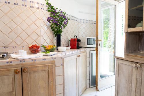 a kitchen with a counter with a vase of flowers at Villa Castello Apartments in Capri