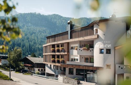 a building with a balcony with flowers on it at Hotel Plan Murin in La Valle