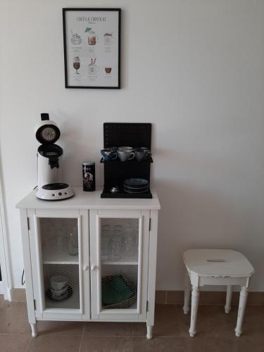 a white cabinet with a table and a stool at Gîte des Agapanthes in Lacroix-sur-Meuse