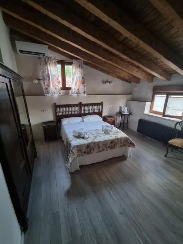 a bedroom with a bed in a room with wooden floors at D' Anta Casa de la Luz in Piedralaves