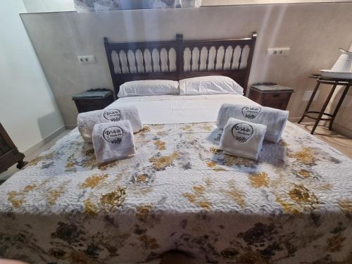 a bedroom with a large bed with two pillows on it at D' Anta Casa de la Luz in Piedralaves