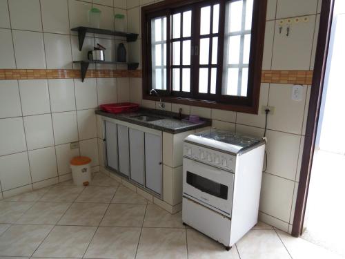a small kitchen with a stove and a sink at APEVO ILHA in Ilha Comprida