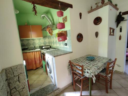 een keuken met een tafel, een fornuis en een wastafel bij SANTANTONIO in Tortolì