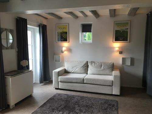 a living room with a white couch and a window at Les Vallées in Fondettes