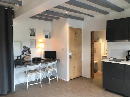 a kitchen with a desk with two chairs and a table with a computer at Les Vallées in Fondettes