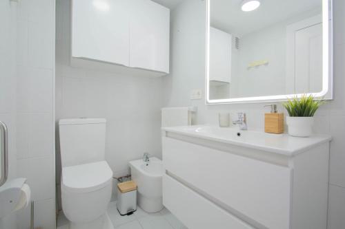 un bagno bianco con un water e un lavandino di Piso Estadio de los Carmenes a Granada