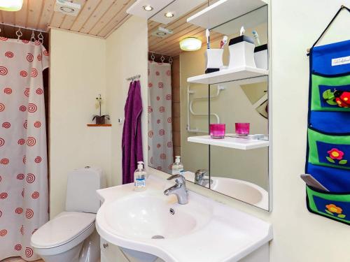 a bathroom with a sink and a toilet and a mirror at Four-Bedroom Holiday home in Spøttrup 2 in Lihme