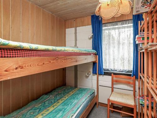 LihmeにあるFour-Bedroom Holiday home in Spøttrup 2の二段ベッド2台と椅子が備わる客室です。