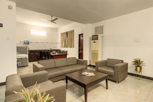 Sala de estar con 2 sofás y mesa de centro en Hotel Paramount Suites & Service Apartments en Mangalore