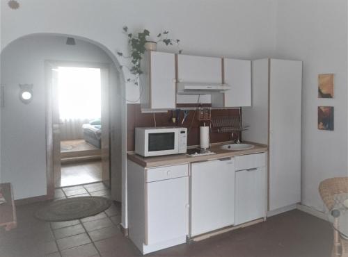a kitchen with white cabinets and a microwave at Down-Town-Oasis in Düsseldorf