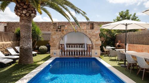a swimming pool in a yard with a palm tree at Casa Mistela in Jalón