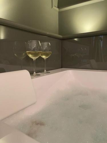 two glasses of wine sitting in a bath tub at Dimora Terranova Charming Rooms in Noto