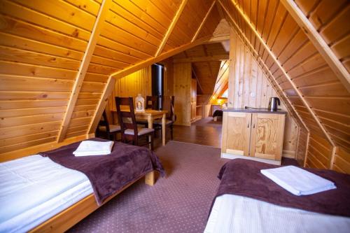 ザコパネにあるWilla Na Szczycieの木造キャビン内のベッドルーム1室(ベッド2台付)