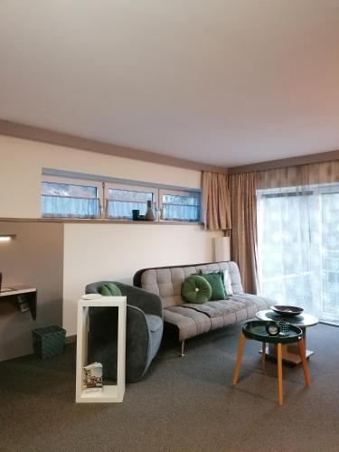 a living room with a couch and a mirror at Business Apartments in Hohenems