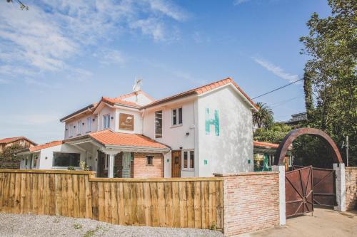 una casa detrás de una valla de madera con una puerta en Hotel La Caracola Suances, en Suances