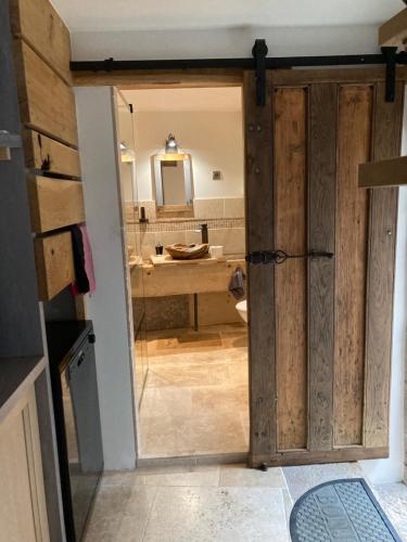 an open door to a bathroom with a sink at La Grange in Avallon