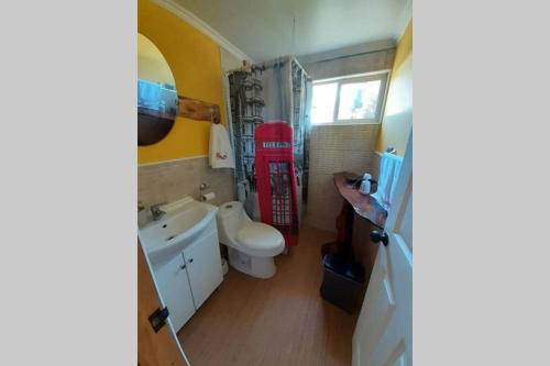 een badkamer met een witte wastafel en een rode telefooncel bij Pillang Likan tinas calientes, el poder del Volcan in Puerto Varas