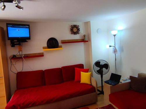 Una sala de estar con un sofá rojo y un televisor. en Studio Yana *Top location*Sea Garden*, en Varna
