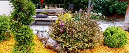 a garden with flowers and a bench in the background at AlpinDesign Kaunertal in Kaunertal