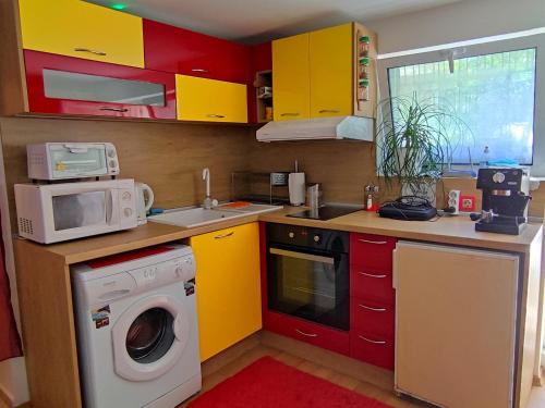 a kitchen with yellow cabinets and a washing machine at Studio Yana *Top location*Sea Garden* in Varna City