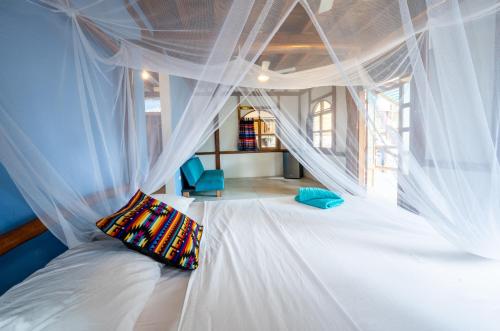 a bedroom with a bed with white mosquito nets at Casa del Sol in Montañita