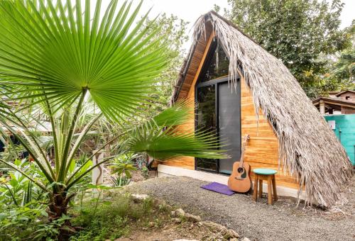a small house with a guitar and a chair at Casa del Sol in Montañita