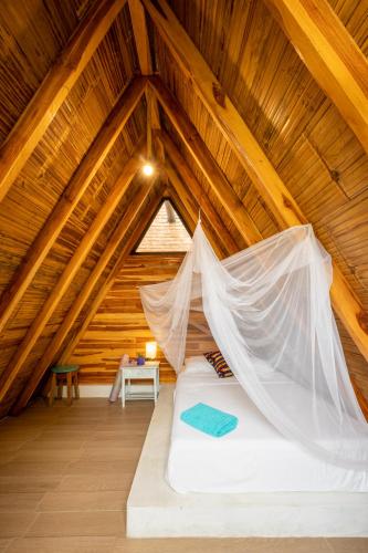 a bed in a attic with a mosquito net at Casa del Sol in Montañita