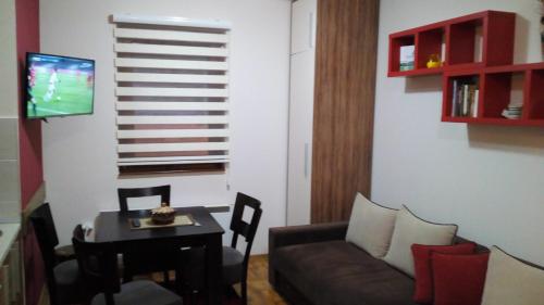 uma sala de estar com um sofá e uma mesa em Zlatibor Katarina apartman em Zlatibor