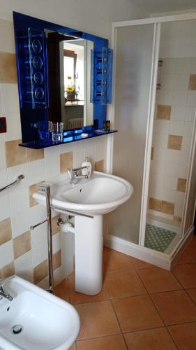 ein Badezimmer mit einem weißen Waschbecken und einer Dusche in der Unterkunft La Ca d'Piazi in Viù