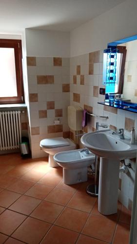 a bathroom with two sinks and a toilet and a window at La Ca d'Piazi in Viù