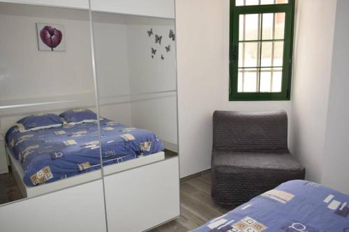 sypialnia z łóżkiem i krzesłem w obiekcie Appartement Bouganville rez-de-chaussée WIFI w mieście Costa de Antigua