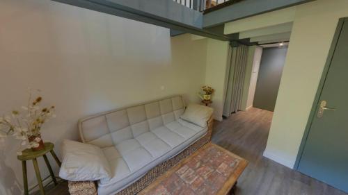 a living room with a white couch and a table at Moulin de Parayre in Les Vignes